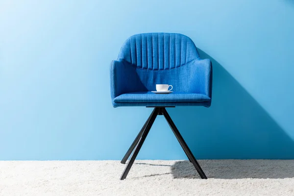 Tasse de café sur la chaise devant le mur bleu — Photo de stock