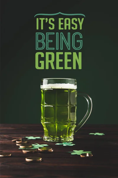 Nahaufnahme eines Bierglases auf einer hölzernen Tischplatte und seines leicht zu bedienenden grünen Schriftzugs — Stockfoto