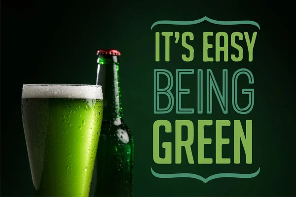 Vista de perto de garrafa e copo de cerveja com a sua fácil ser letras verdes — Fotografia de Stock