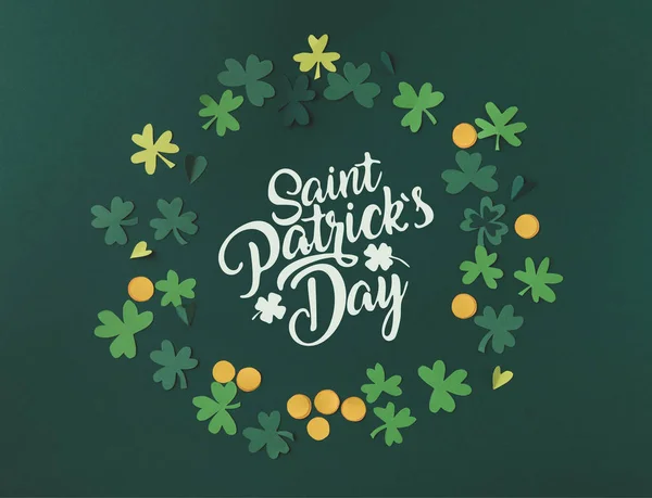 Top view of shamrocks and coins with saint patricks day lettering — Stock Photo