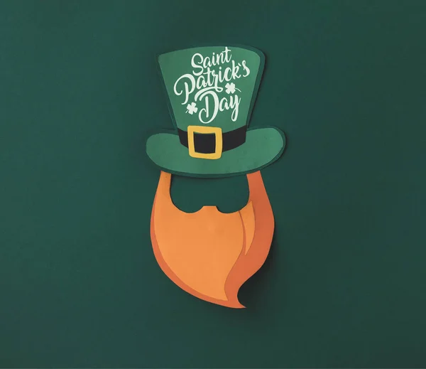 Close up view of papercraft green hat and beard with saint patricks day lettering on green background — Stock Photo