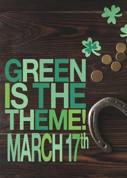 Couché plat avec des pièces de monnaie et fer à cheval sur table en bois avec du vert est le thème, Mars 17 lettrage — Photo de stock