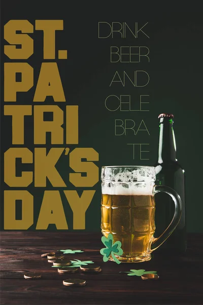 Vista de cerca de la botella y el vaso de cerveza en la mesa de madera con letras de día st patricks - foto de stock