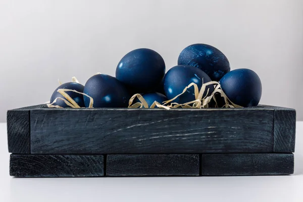 Ovos de páscoa pintados de azul em caixa de madeira com feno decorativo — Fotografia de Stock