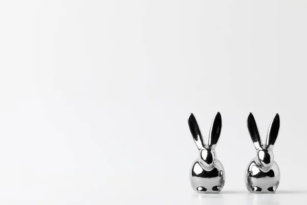 Two statuettes of silver easter bunnies on white — Stock Photo