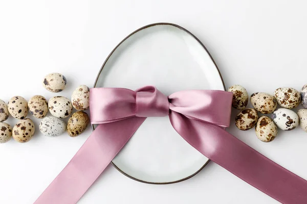 Vue de dessus de la plaque en forme d'oeuf avec des oeufs de caille sur blanc, concept de Pâques — Photo de stock