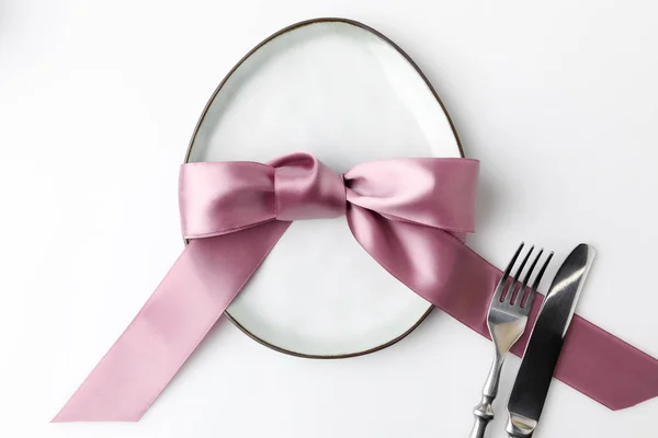 Vue de dessus de la plaque en forme d'oeuf avec fourchette, couteau et ruban, concept de Pâques — Photo de stock