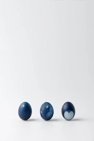 Tres huevos de Pascua pintados de azul sobre blanco - foto de stock