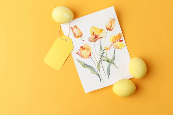 Top view of yellow painted easter eggs with postcard on yellow — Stock Photo