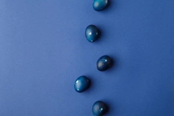 Vue de dessus des oeufs de Pâques peints en bleu sur bleu — Photo de stock