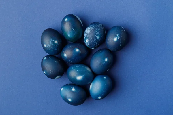 Vista superior de huevos de Pascua pintados de azul sobre azul - foto de stock