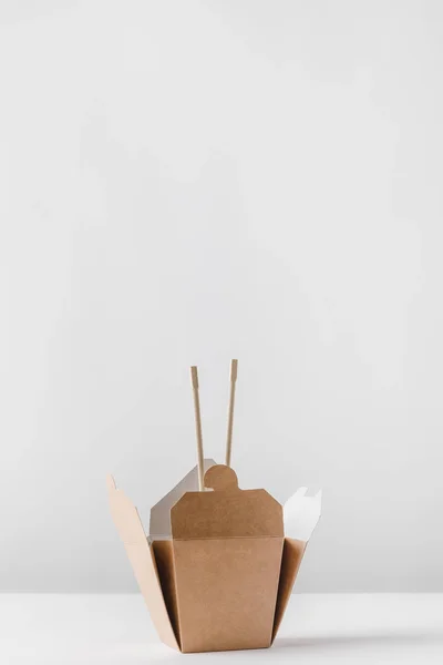 Noodles box with chopsticks on white table — Stock Photo