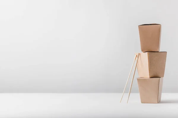 Три коробки с лапшой и палочками на столе — стоковое фото