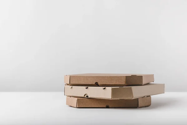 Three pizza boxes on white tabletop — Stock Photo