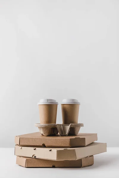 Café en tazas de papel en cajas de pizza en la mesa - foto de stock