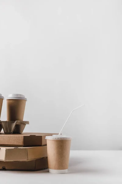 Cajas de pizza y café en tazas de papel en la mesa - foto de stock