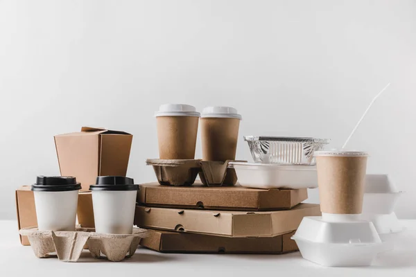 Cajas de pizza y café en tazas de papel con cajas wok en la mesa — Stock Photo