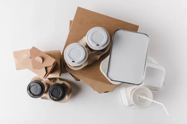 Vista superior de cajas de pizza y café en tazas de papel con cajas wok en la mesa - foto de stock