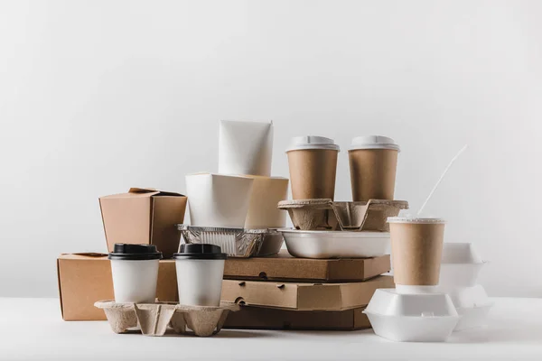 Pizza boxes and disposable coffee cups with take away boxes on tabletop — Stock Photo