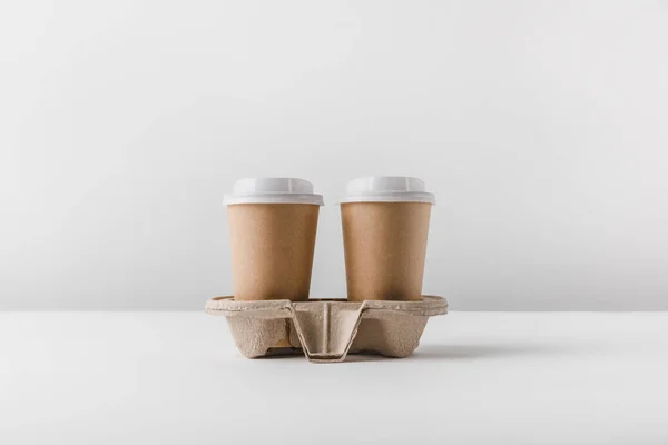 Two coffee in paper cups in cardboard tray on tabletop — Stock Photo