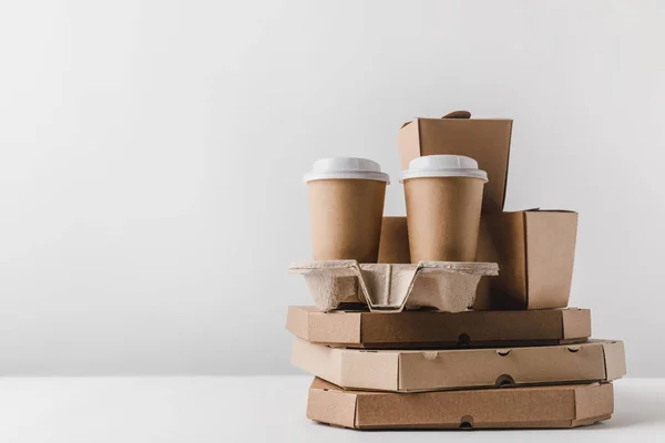 Pizza boxes and disposable coffee cups with noodles boxes on table — Stock Photo