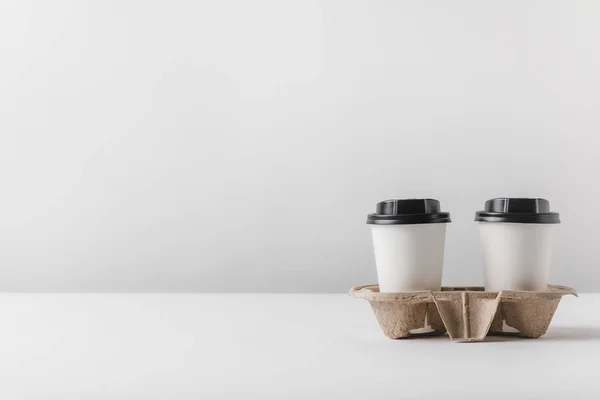 Two coffee in paper cups in cardboard tray on table — Stock Photo