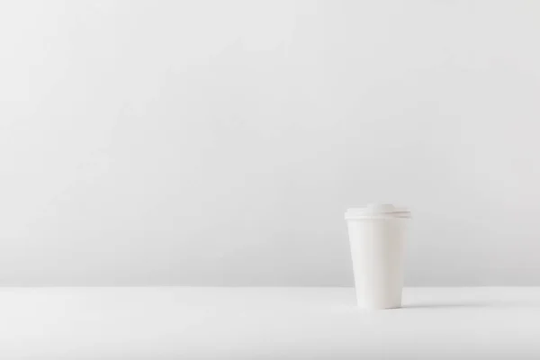 White disposable coffee cup on white tabletop — Stock Photo