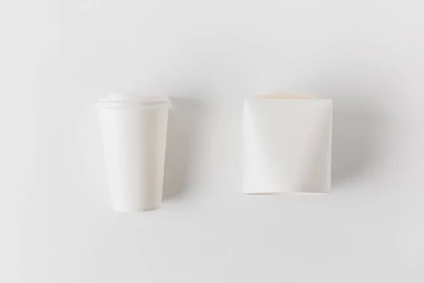 Верхний вид кофе в бумажной чашке и коробке с лапшой на белой поверхности — стоковое фото