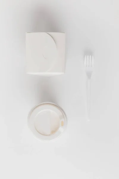 Top view of coffee to go, noodles box and fork on white — Stock Photo