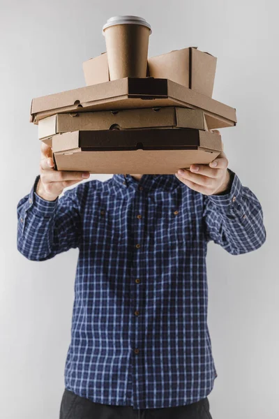 Correio segurando caixas de pizza e caixas de macarrão isolado em branco — Fotografia de Stock