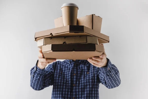 Courier holding pizza boxes and coffee in paper cup isolated on white — Stock Photo