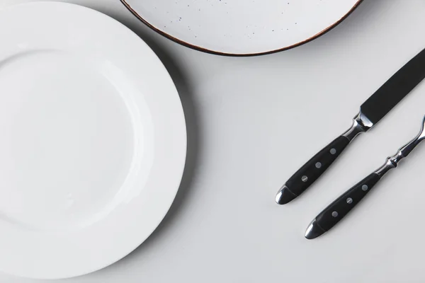 Two different plates with cutlery, table appointments conception — Stock Photo