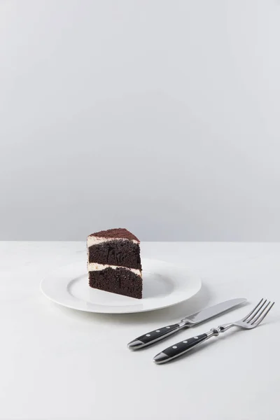 Chocolate cake on plate and fork with knife — Stock Photo