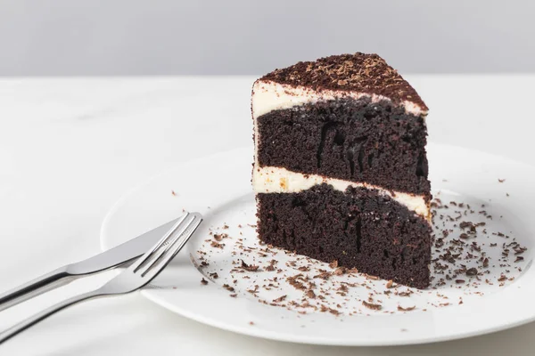Vista da vicino della torta al cioccolato con smalto sul piatto bianco — Foto stock