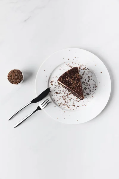 Chocolat râpé dans un bol et gâteau avec glaçure sur plaque — Photo de stock