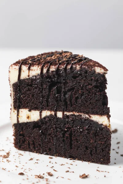 Vue rapprochée du gâteau au chocolat avec glaçure sur plaque blanche — Photo de stock