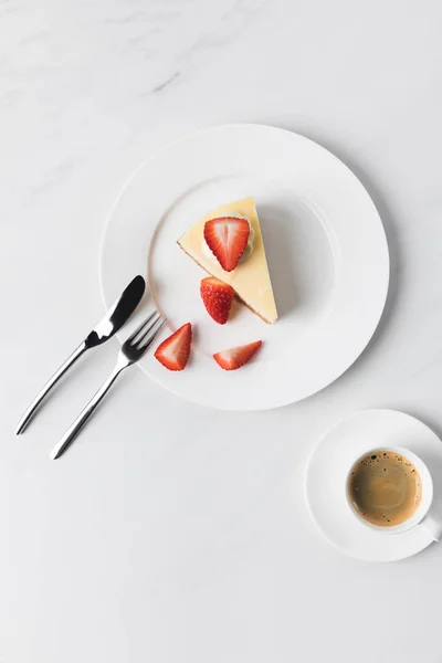 Cutlery, coffee cup and plate with strawberry cheesecake — Stock Photo