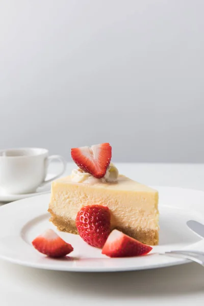 Vista close-up de xícara de café e prato com cheesecake de morango — Fotografia de Stock