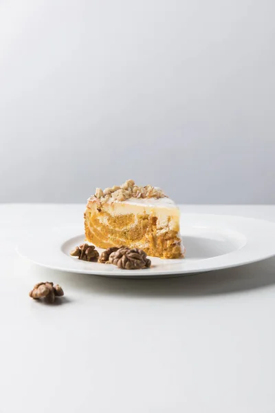 Vue rapprochée du gâteau sur une assiette entourée de noix — Photo de stock