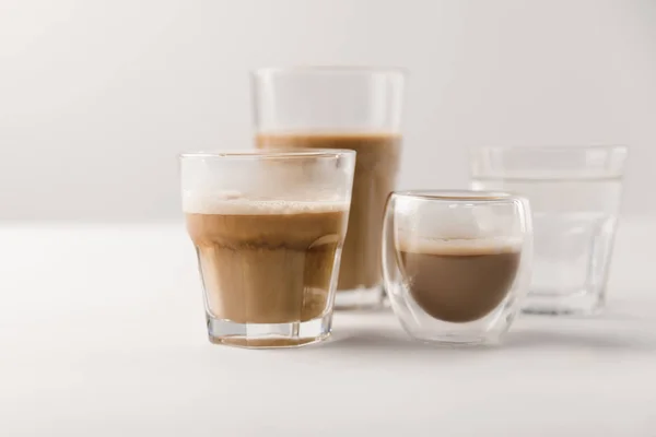Vasos con café y leche sobre fondo blanco - foto de stock