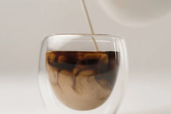 Preparing coffee with milk on white background — Stock Photo