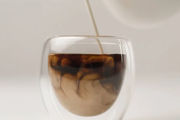 Preparación de café con leche sobre fondo blanco - foto de stock