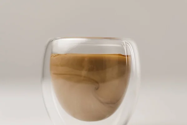 Taza de vidrio de doble pared con café y leche sobre fondo blanco - foto de stock