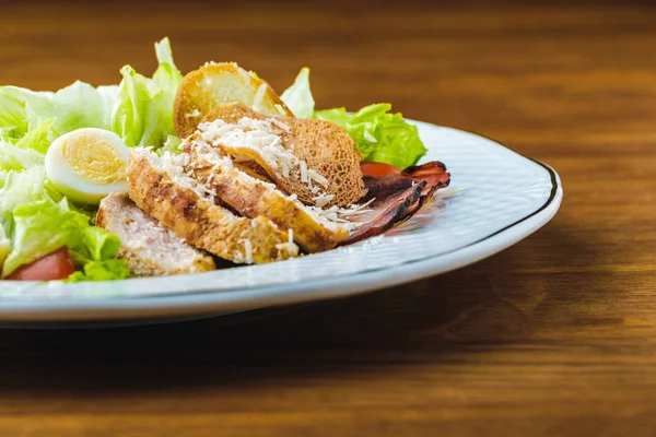 Vista de cerca de la deliciosa ensalada César en la mesa de madera - foto de stock