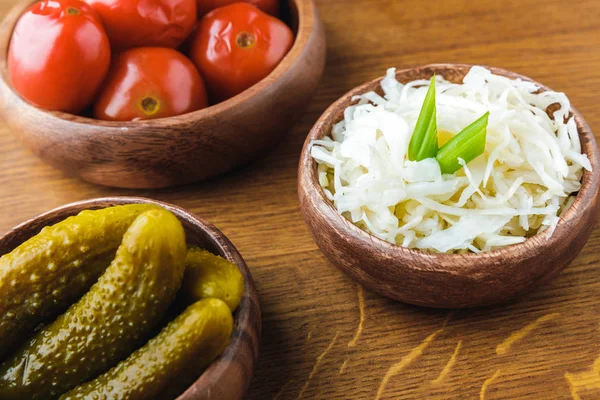 Close-up view of delicious pickled vegetables in bowls on wooden tabletop — Stock Photo