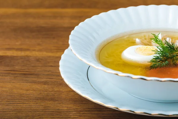 Vista ravvicinata di deliziosa zuppa sana con uovo e aneto su un tavolo di legno — Foto stock