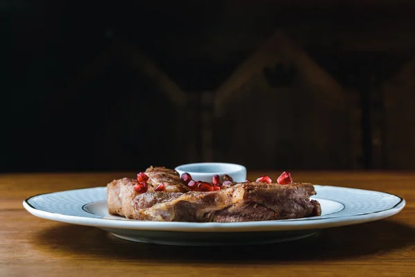 Vista ravvicinata di deliziose bistecche alla griglia con semi di melograno sul piatto — Foto stock