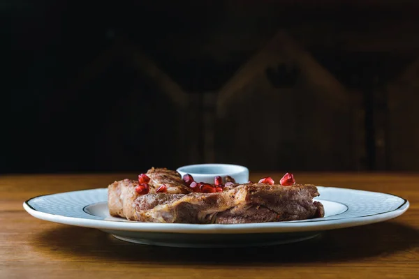 Nahaufnahme von leckeren gegrillten Steaks mit Granatapfelkernen auf dem Teller — Stockfoto