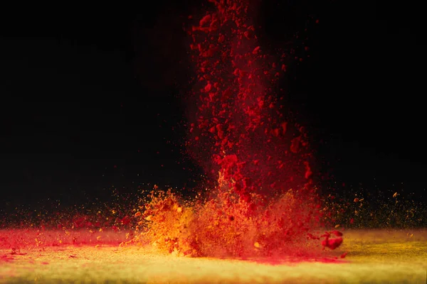 Explosion de poudre holi orange sur noir, fête du printemps hindou — Photo de stock