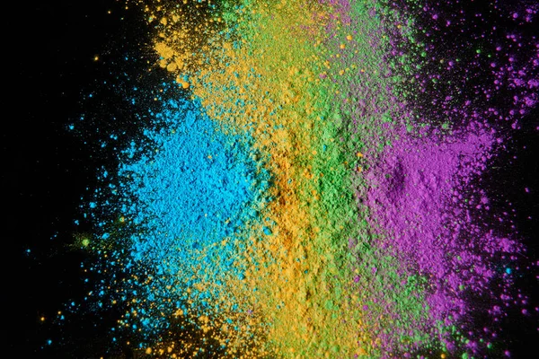 Vista dall'alto della polvere di holi colorata isolata sul nero, festival primaverile indù — Foto stock